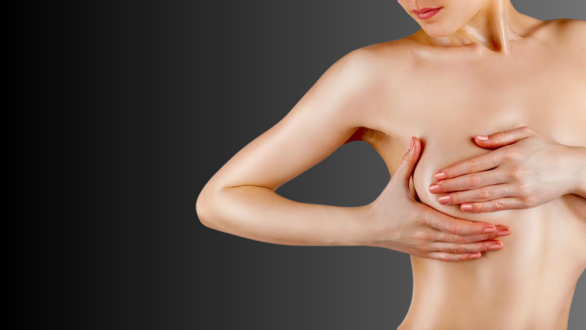Woman examining her breasts with hands against a dark background.