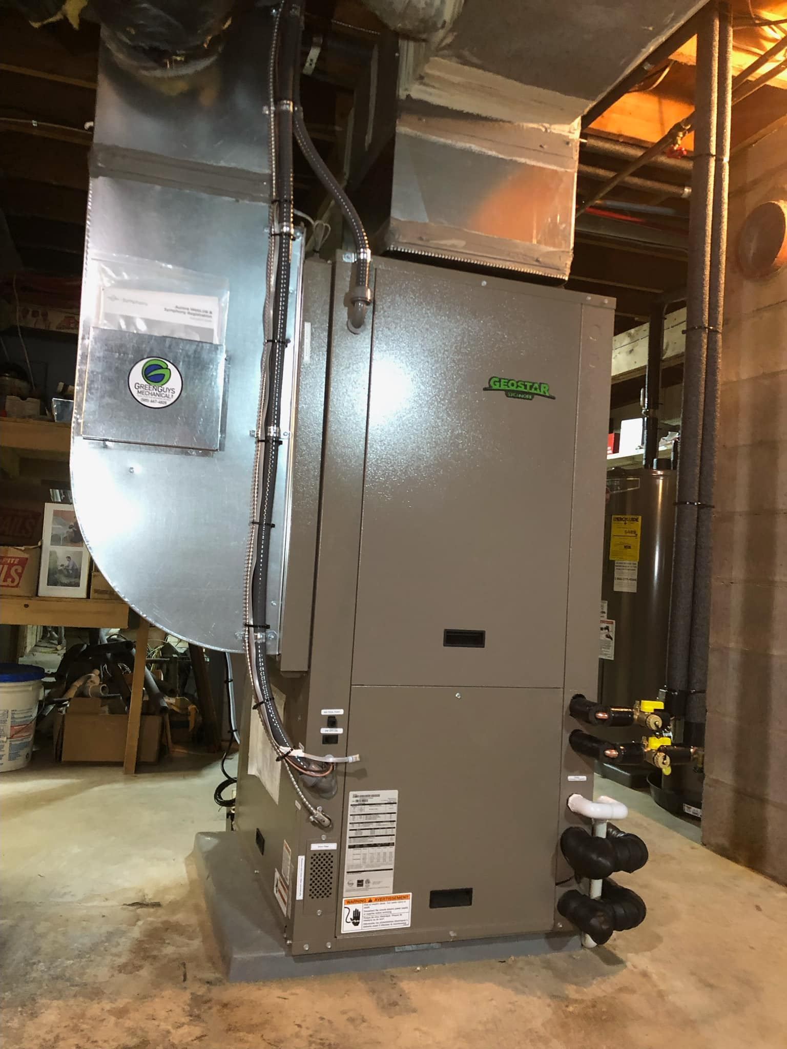 Gray HVAC unit with ductwork in a basement.