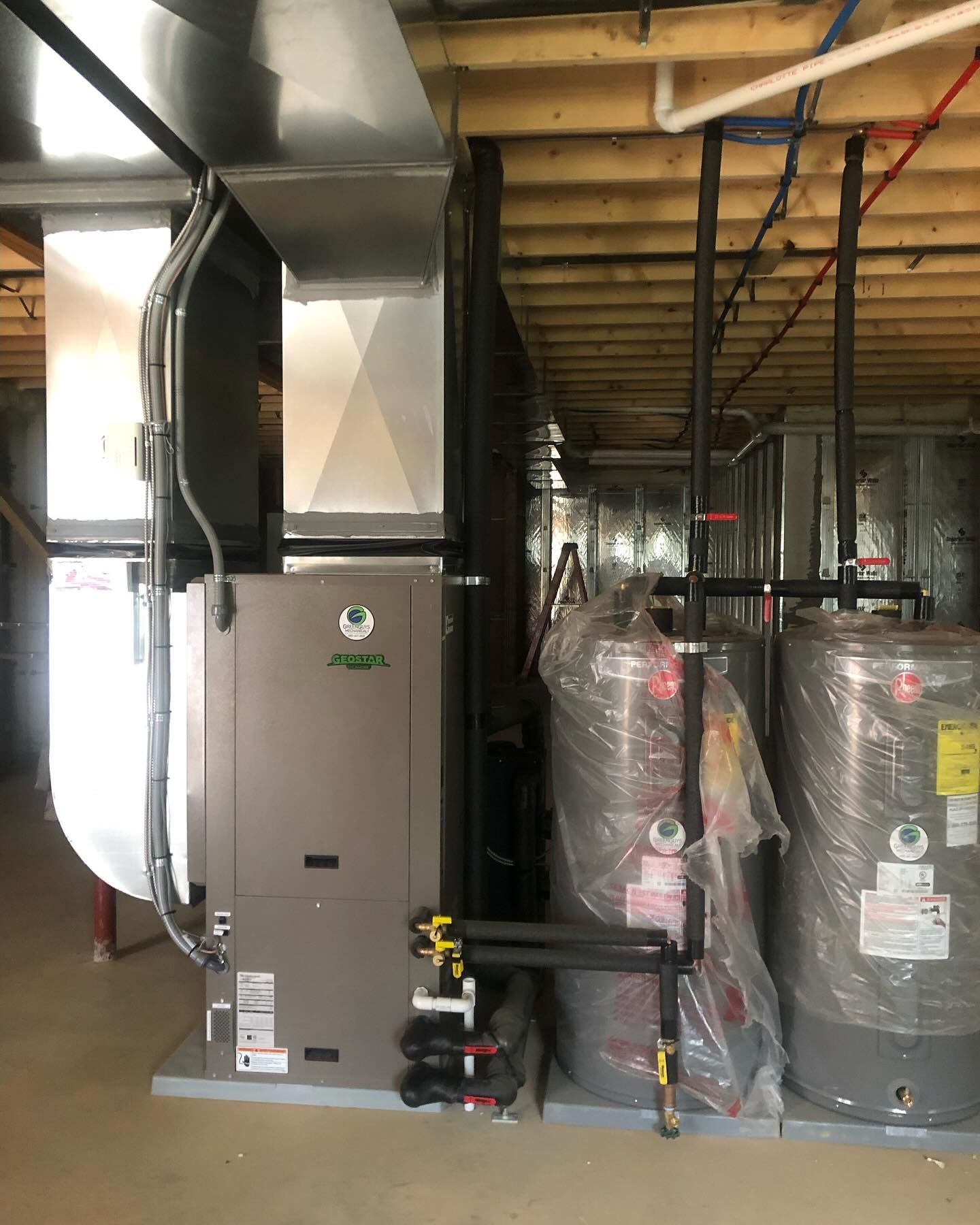 HVAC unit with ductwork, water heaters, and pipes in a basement.