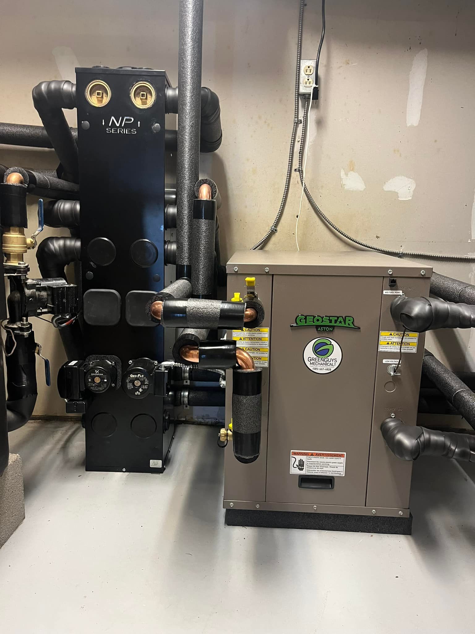 Industrial HVAC equipment in a mechanical room, featuring pipes, valves, and insulation.