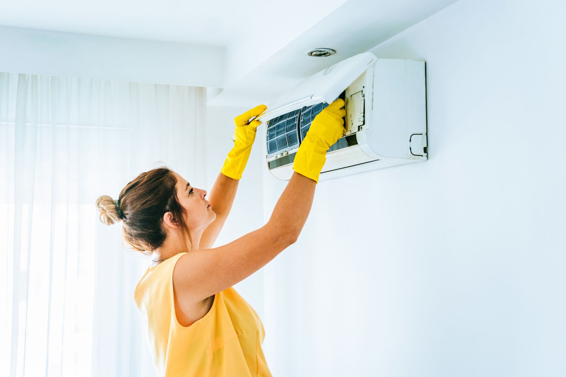 Woman Cleaning Air Conditioning System.