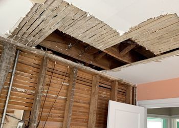 A ceiling with a lot of stains on it and a light on it.