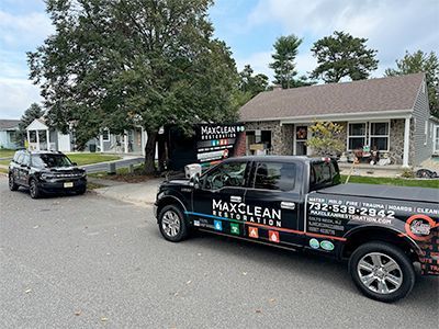 A black truck is parked in front of a house.