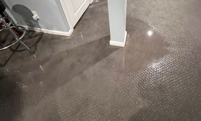 A wet floor in a room with a chair and a door.