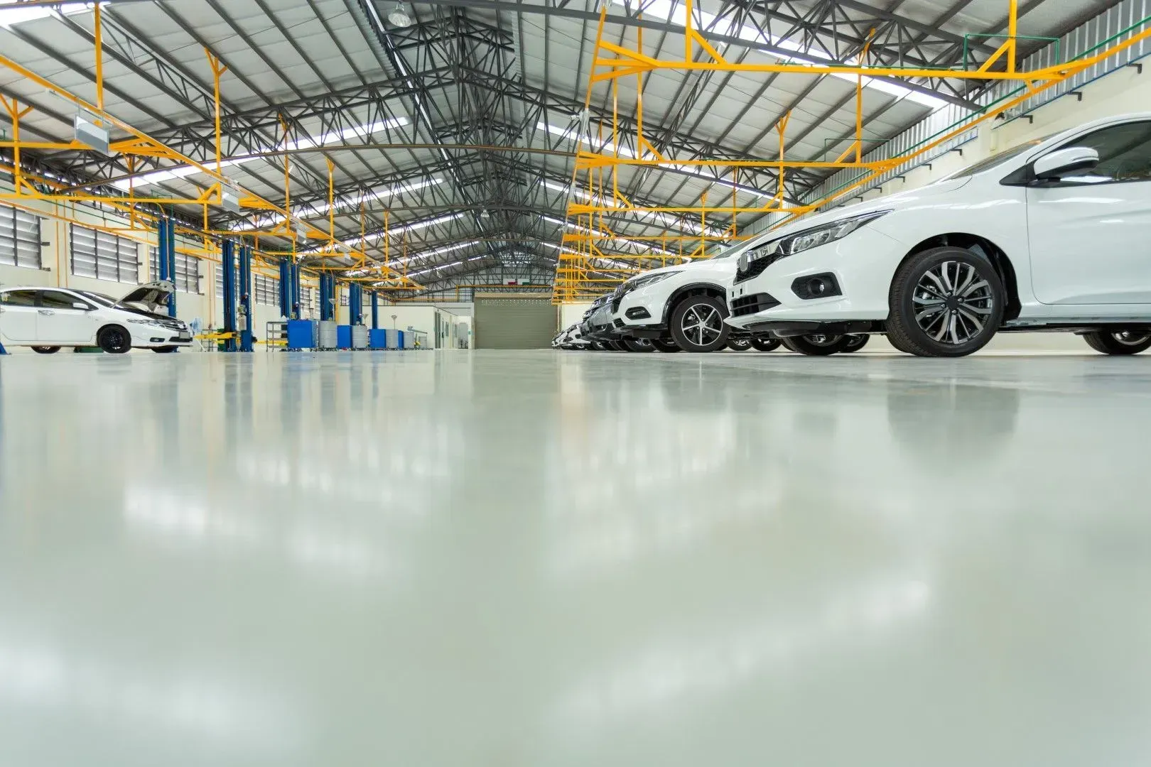 Industrial-grade epoxy flooring in a large automotive service center.
