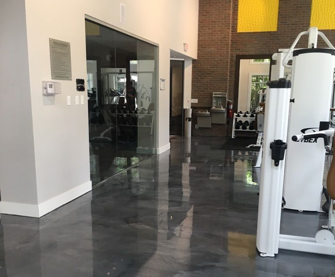 Durable high-gloss epoxy flooring in a modern commercial gym.