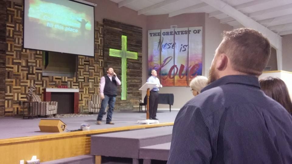 A man is standing in front of a cross in a church