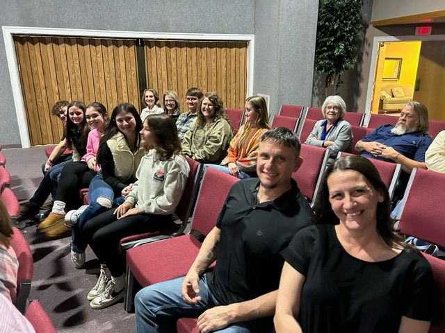 A man is standing in front of a cross in a church