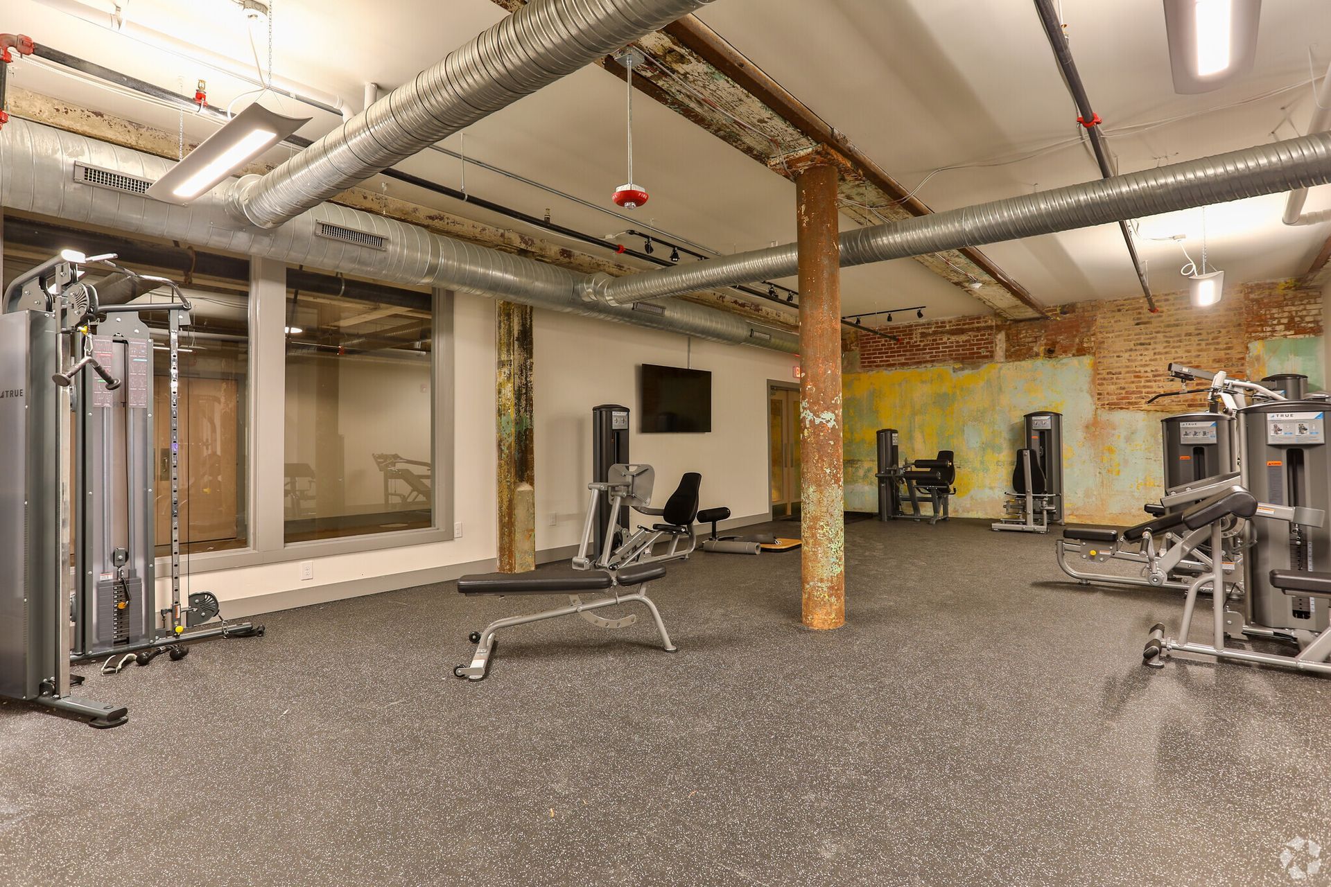 A large gym filled with lots of exercise equipment.