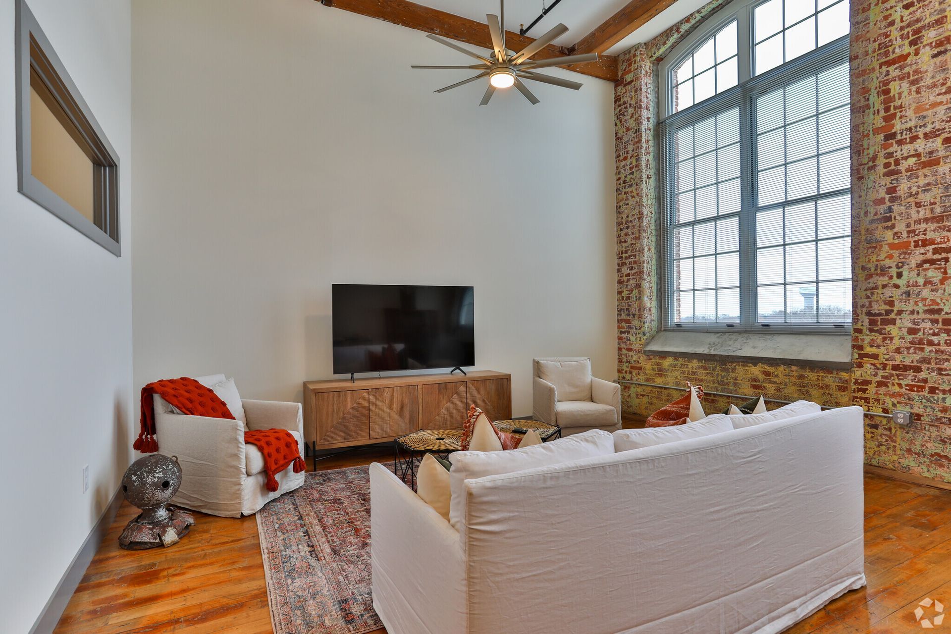 A living room with a couch, chair, and a flat screen tv.