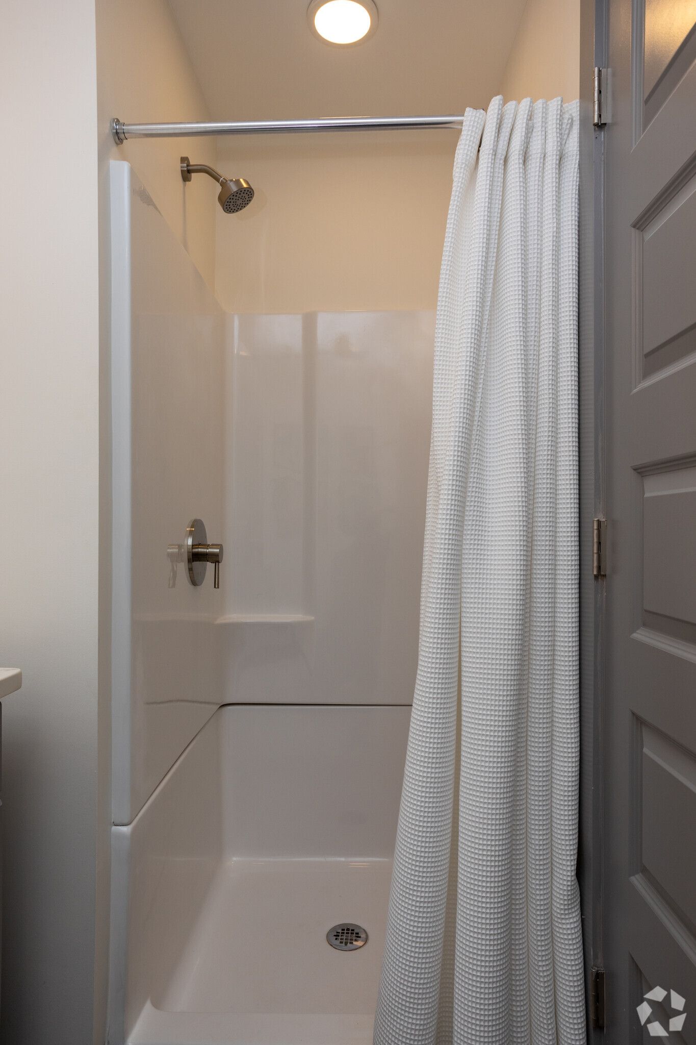 A bathroom with a shower curtain and a bathtub.