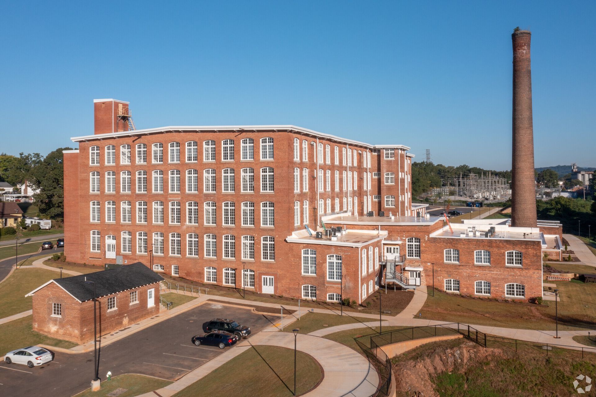 An aerial view of a large brick building with a chimney in the background.