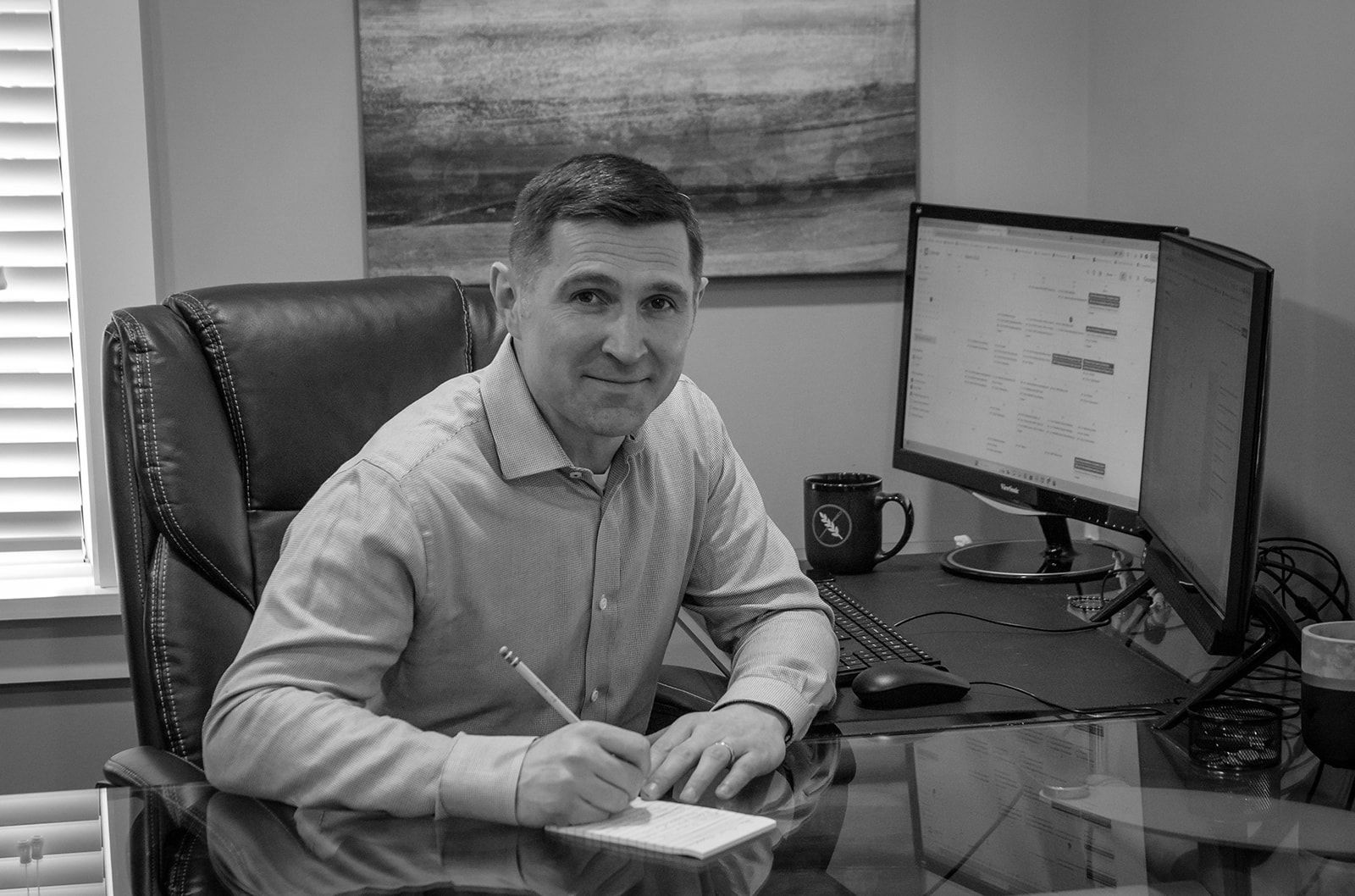 A man is sitting at a desk in front of a computer.
