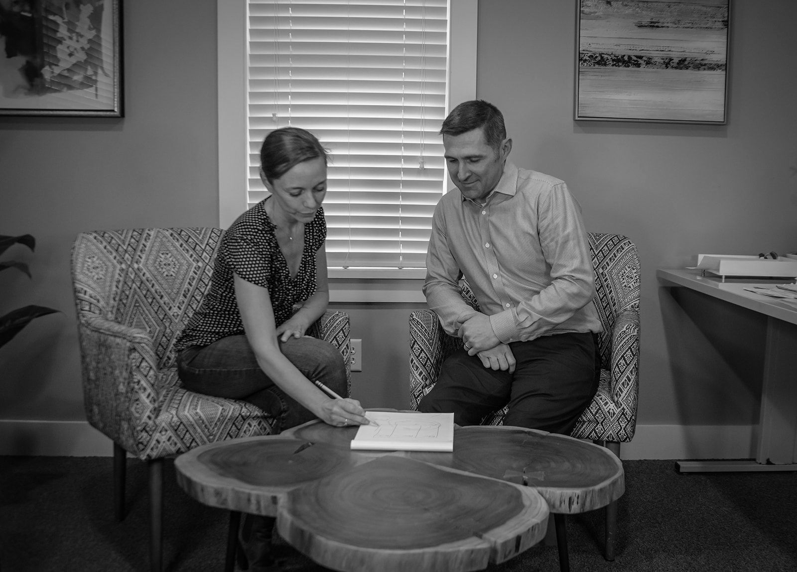 A man and a woman are sitting at a table looking at a piece of paper.