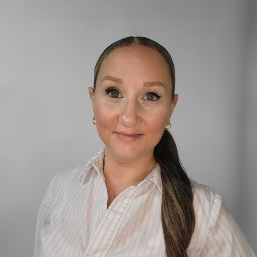 The woman is wearing a white sweater and smiling for the camera.