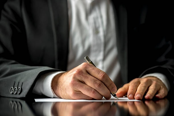 Close-up of lawyer signing documents, showcasing a probate lawyer working with precision.