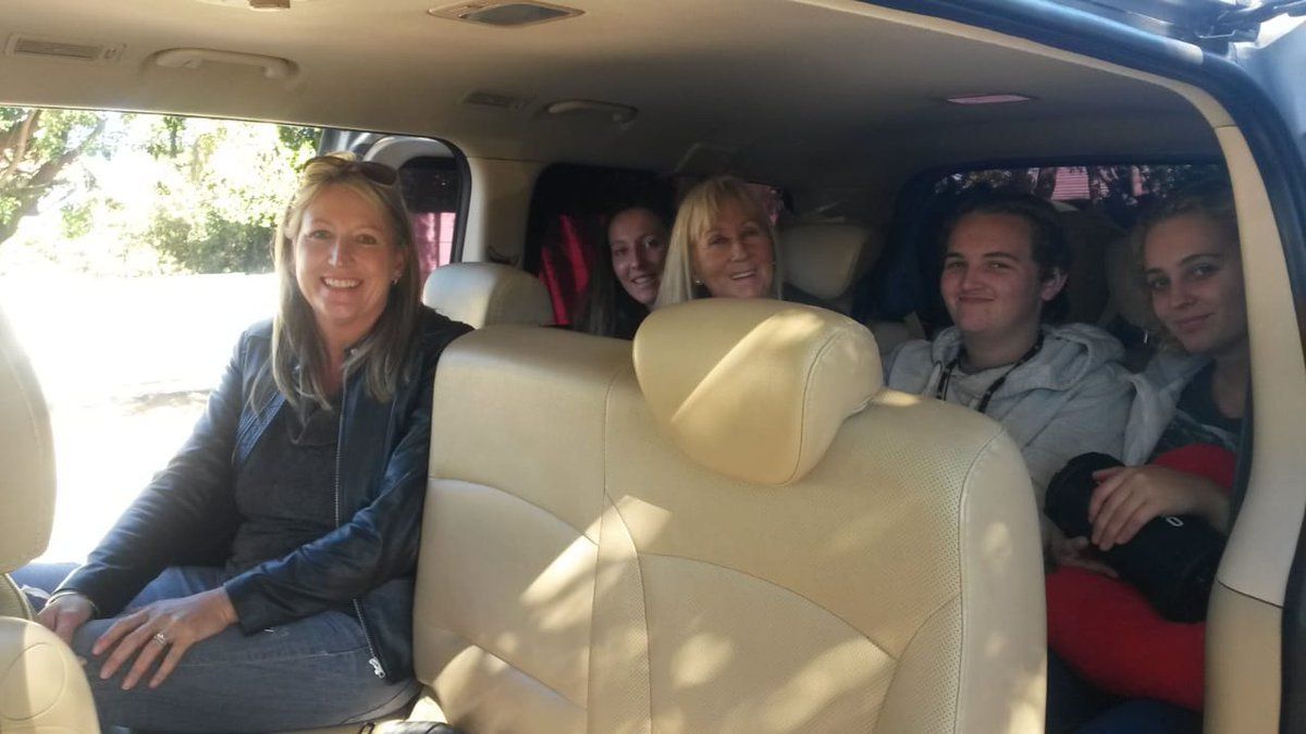 A group of people are sitting in the back seat of a car.