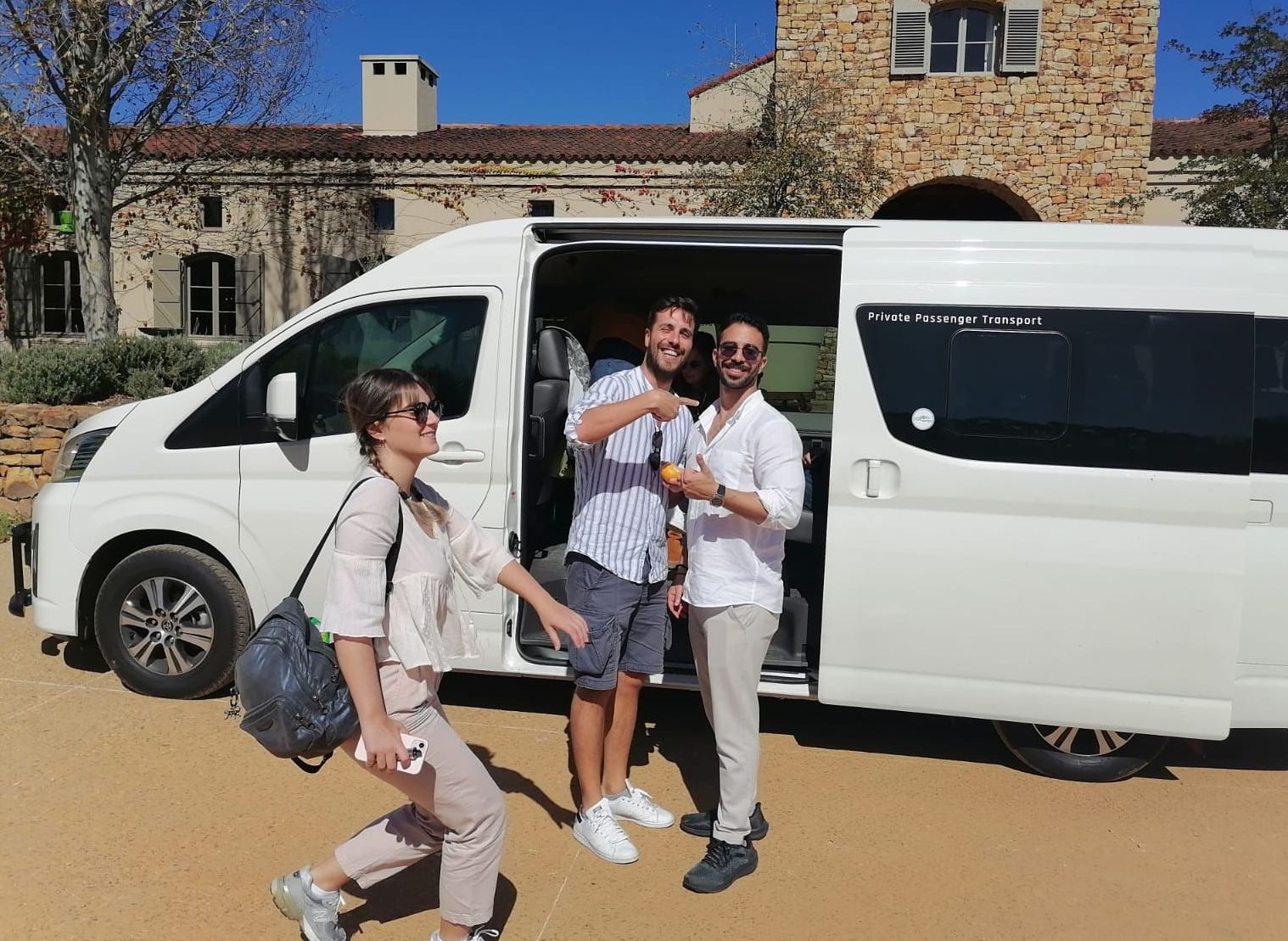 Three people are standing in front of a white van.