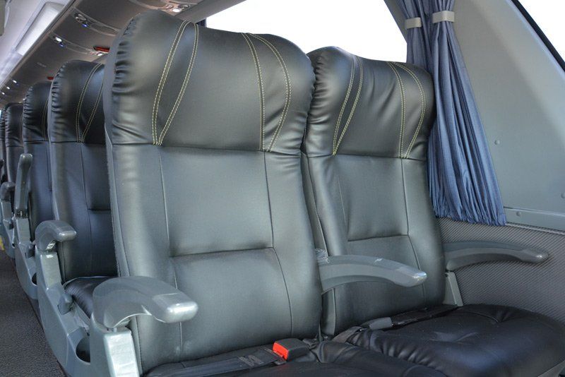 A row of black leather seats on a bus