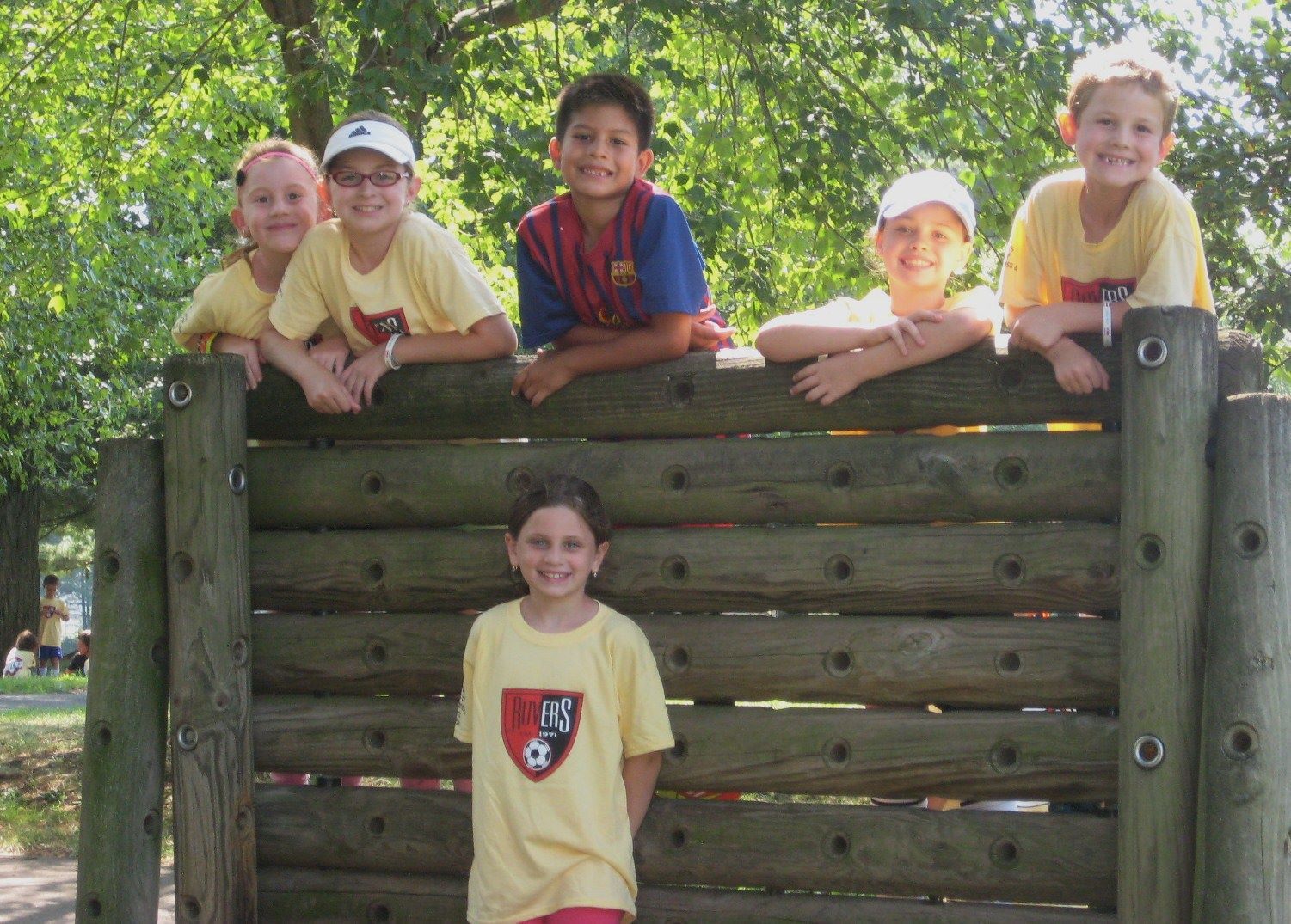 a girl wearing a yellow shirt with a shield on it