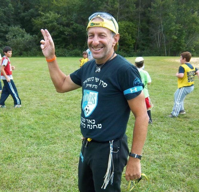 a man wearing a black t-shirt with a shield on it