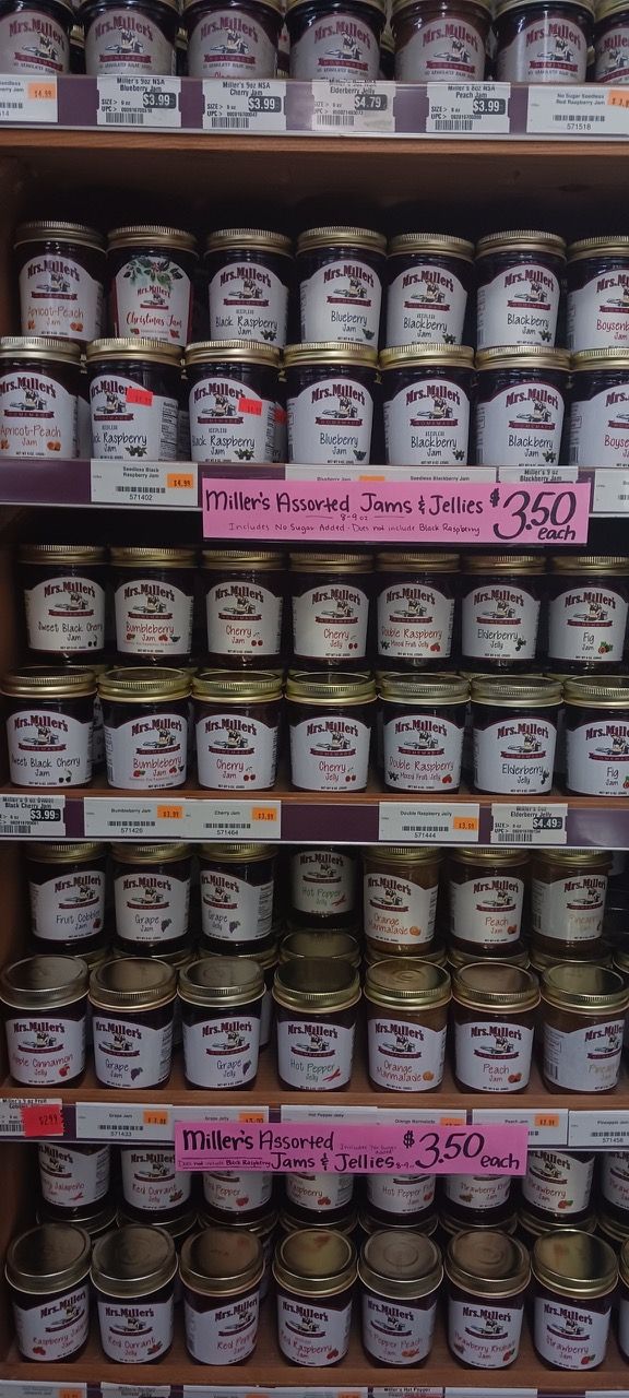 A shelf filled with jars of jam and jelly.