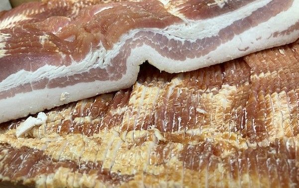 A plate of meat and lemons on a table.