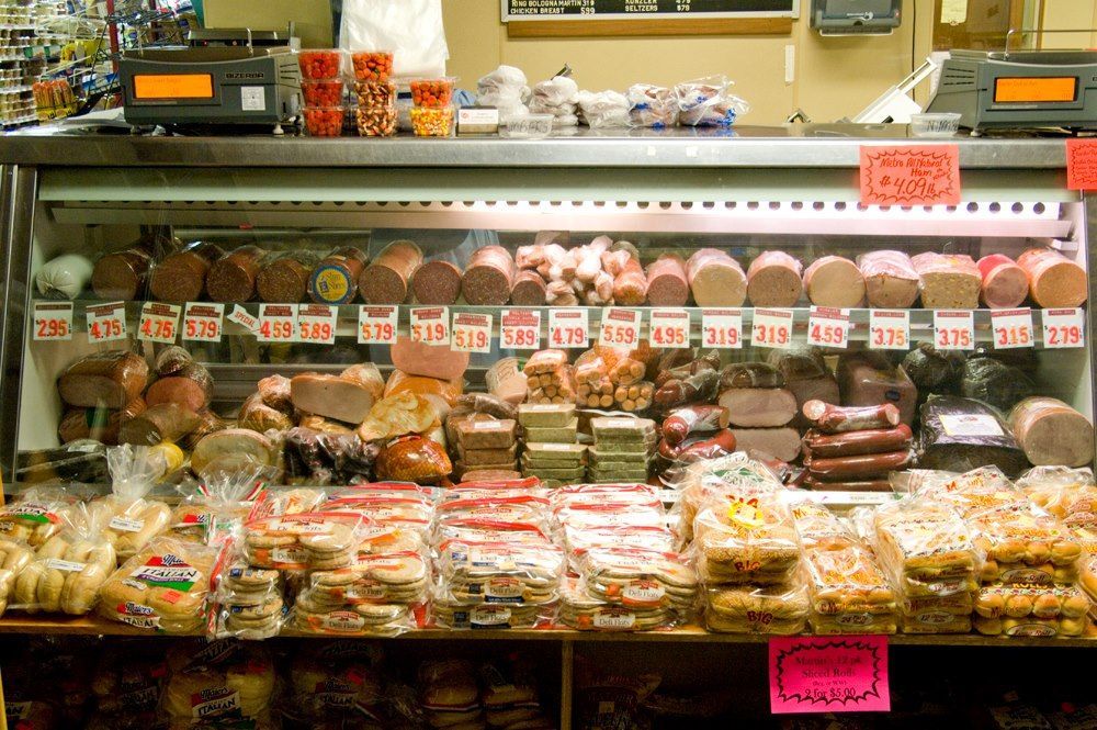 A display case filled with a variety of meats and cheeses