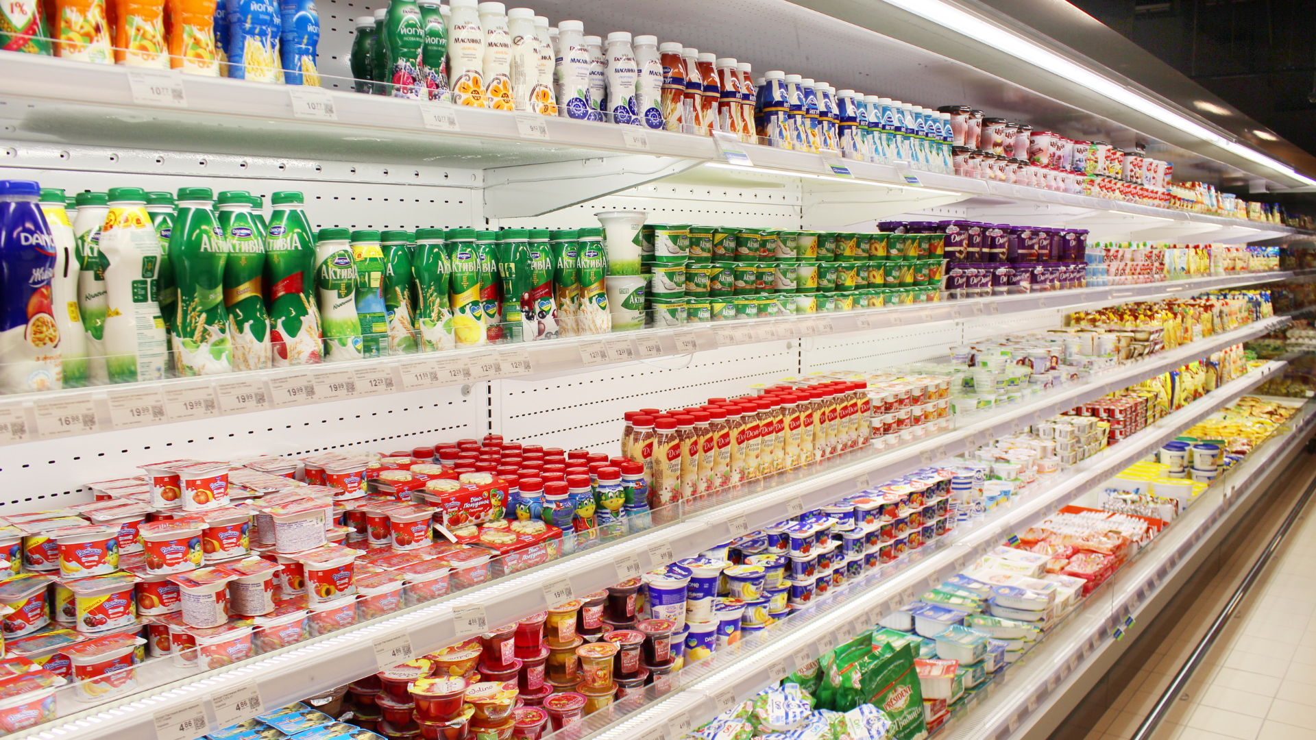 A refrigerated section of a grocery store filled with lots of food.