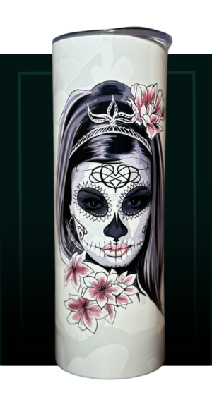 A cylindrical tumbler featuring a Day of the Dead style skull face design adorned with floral accents and a headpiece.