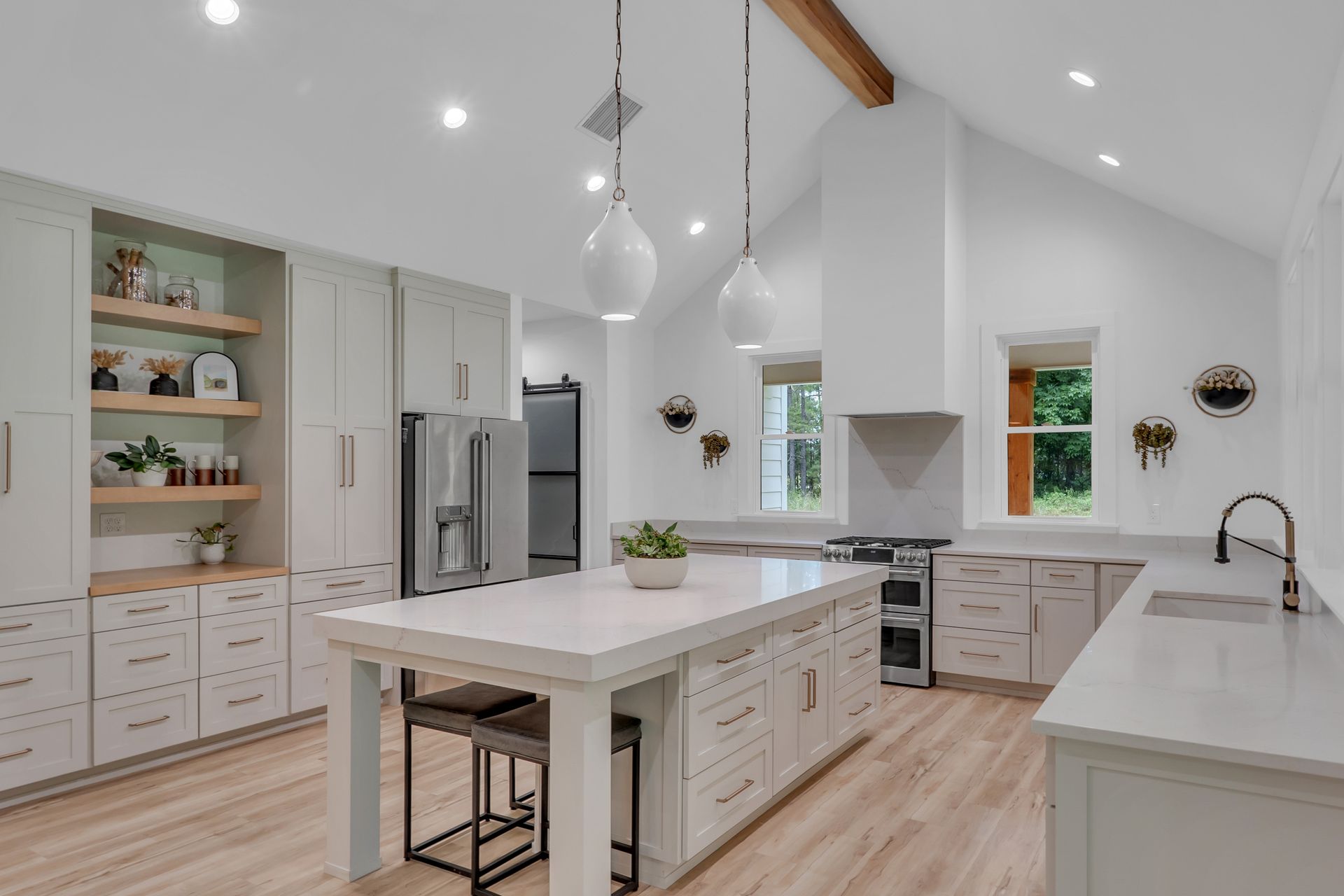 A kitchen with white cabinets and a large island in the middle.