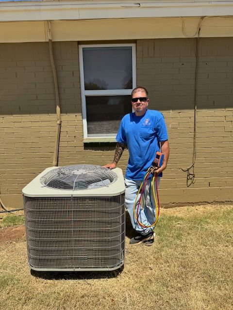 A man is standing next to an air conditioner in front of a house.