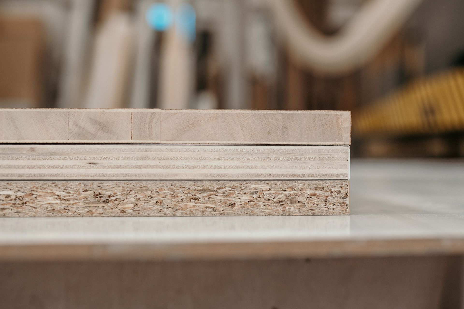 Tre tipi di legno impilati: truciolato, compensato e un pannello di legno massello.