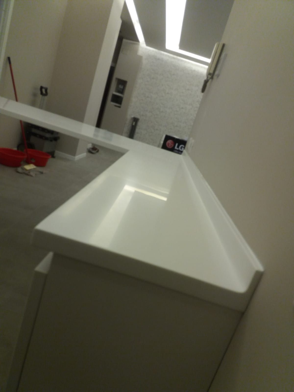 Piano di lavoro bianco con angolo obliquo in una stanza moderna e ben illuminata.