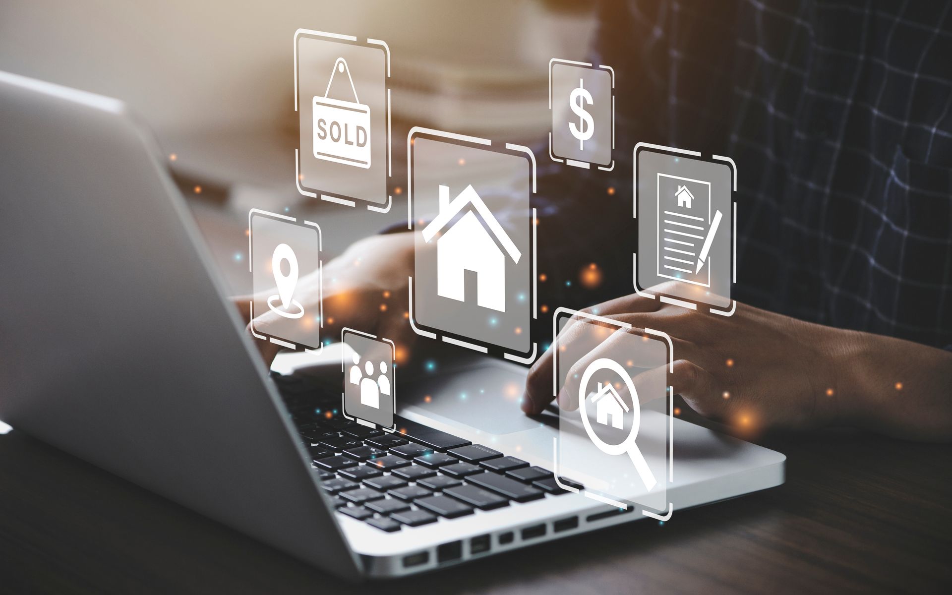Laptop with smart home icons floating above a person typing on a keyboard, including home, cloud, and security symbols