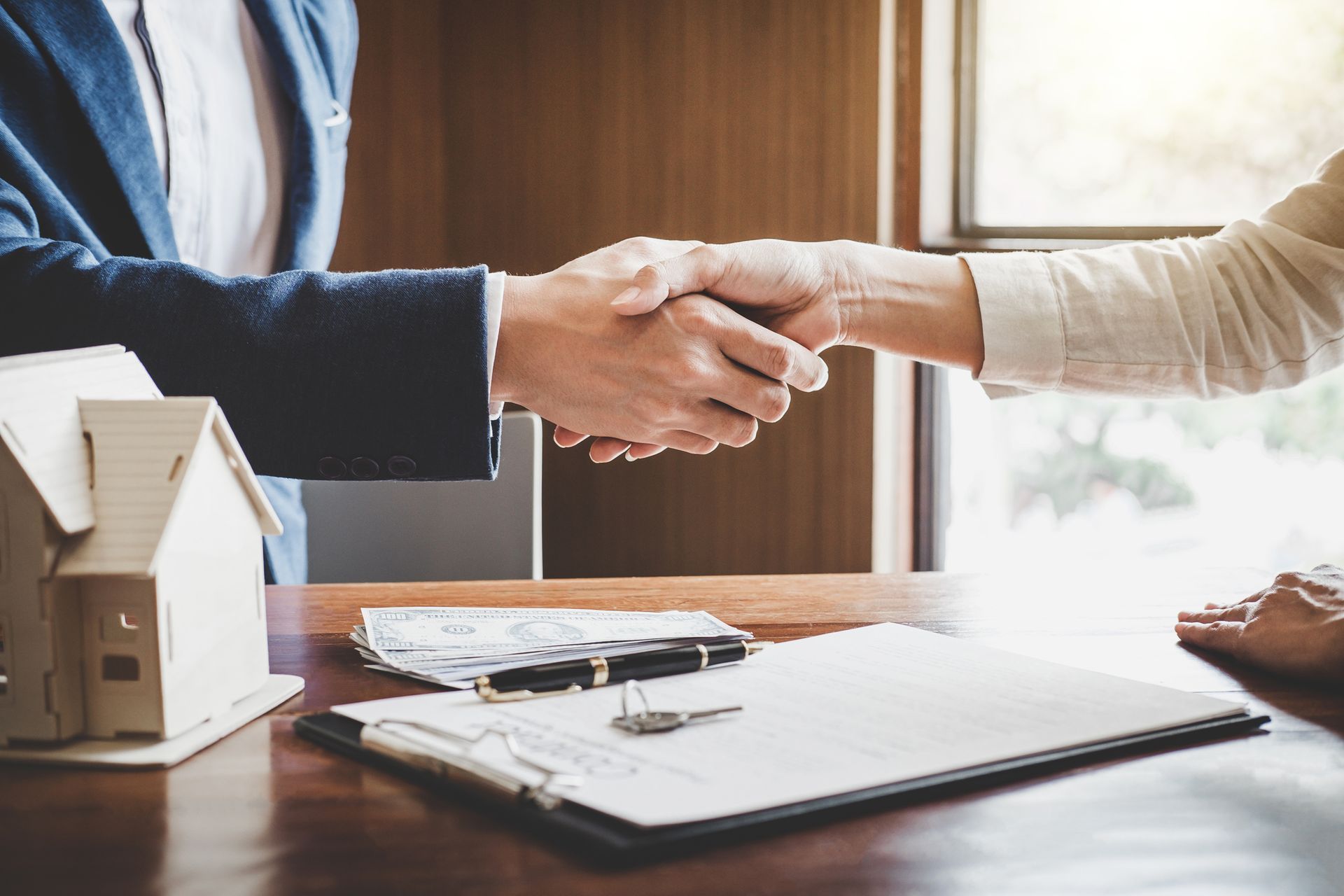 Agent and client handshake, showcasing real estate appraiser in loan and investment deals.