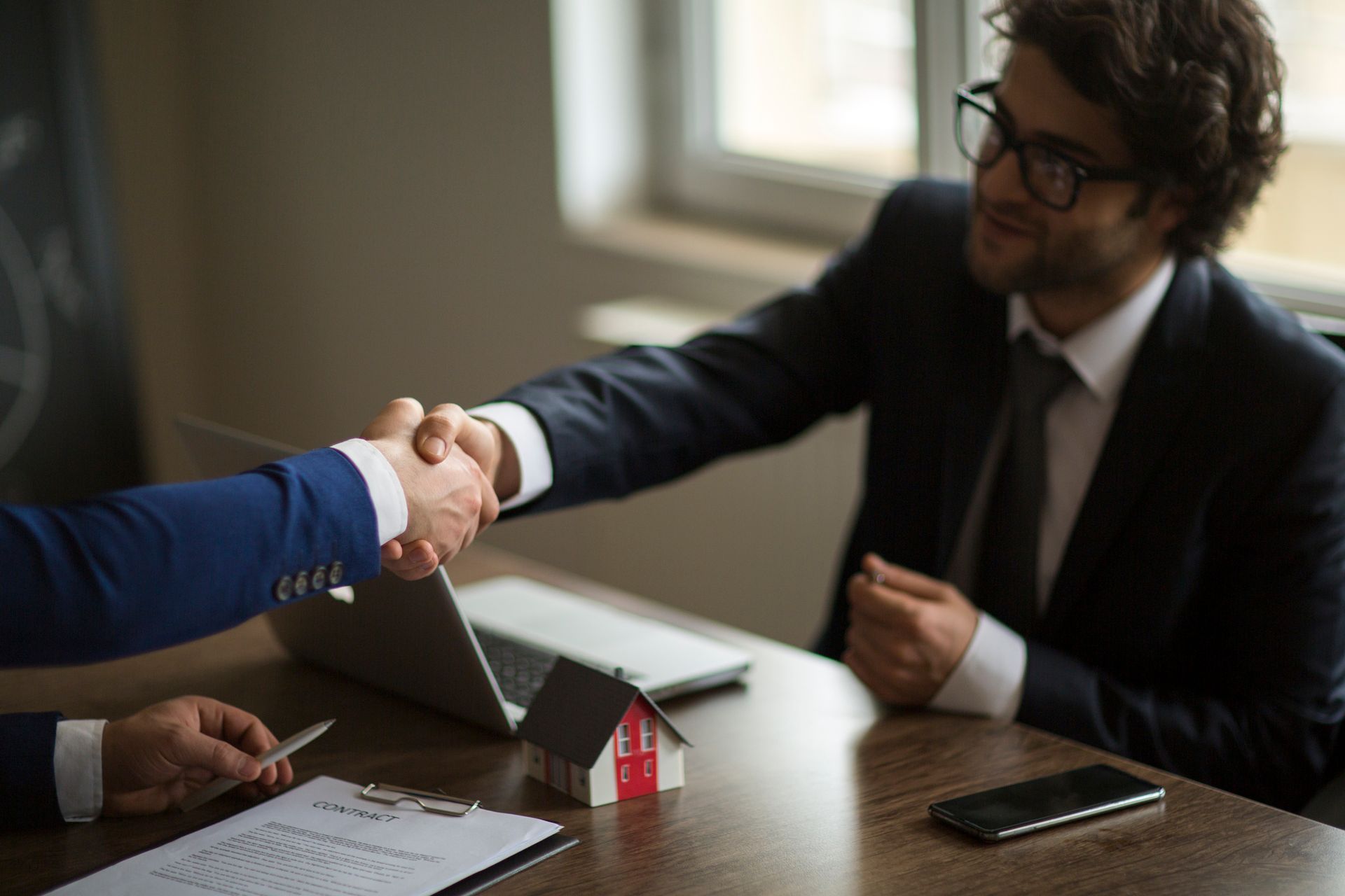 Handshake closing a deal, showcasing real estate appraiser expertise in action.