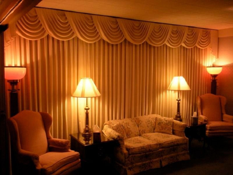 A living room with a couch and chairs and lamps