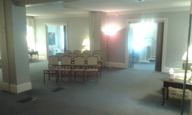 A room with a table and chairs in it and a lamp.