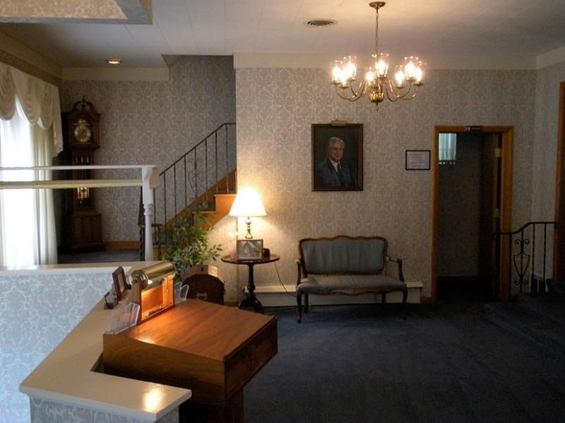 A room with a clock and a picture of a man on the wall