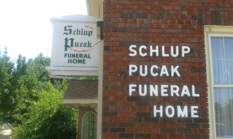 A brick building with a sign for schlup pucak funeral home