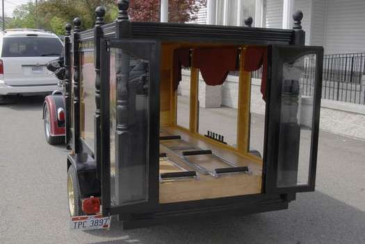 A coffin is parked on the side of the road