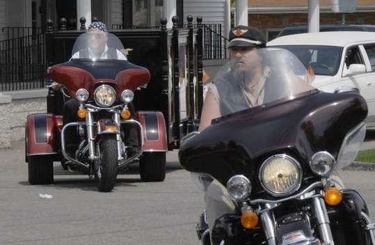 A man is riding a motorcycle with a sidecar attached to it
