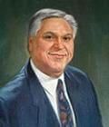 A man in a suit and tie is smiling for the camera.