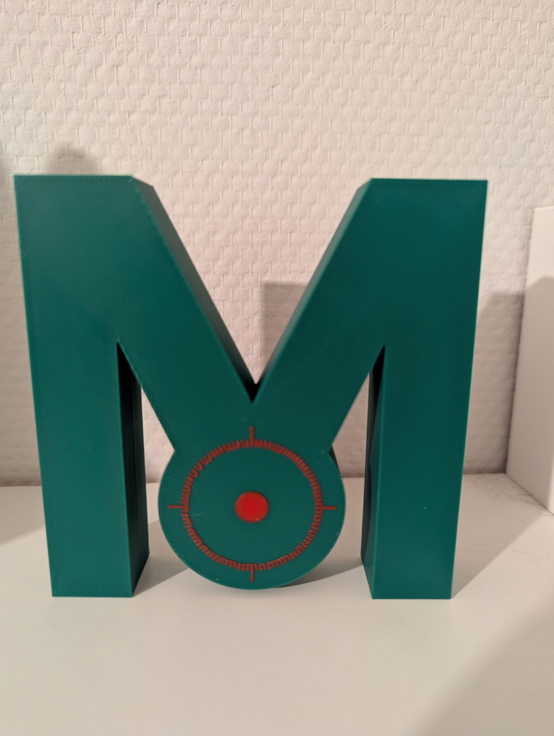 Rig-3d Een turquoisekleurige, driedimensionale letter