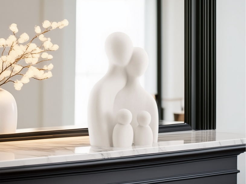 Rig-3d Een wit, minimalistisch beeld van een gezin met vier figuren staat op een marmeren schoorsteenmantel voor een spiegel met een zwarte lijst.