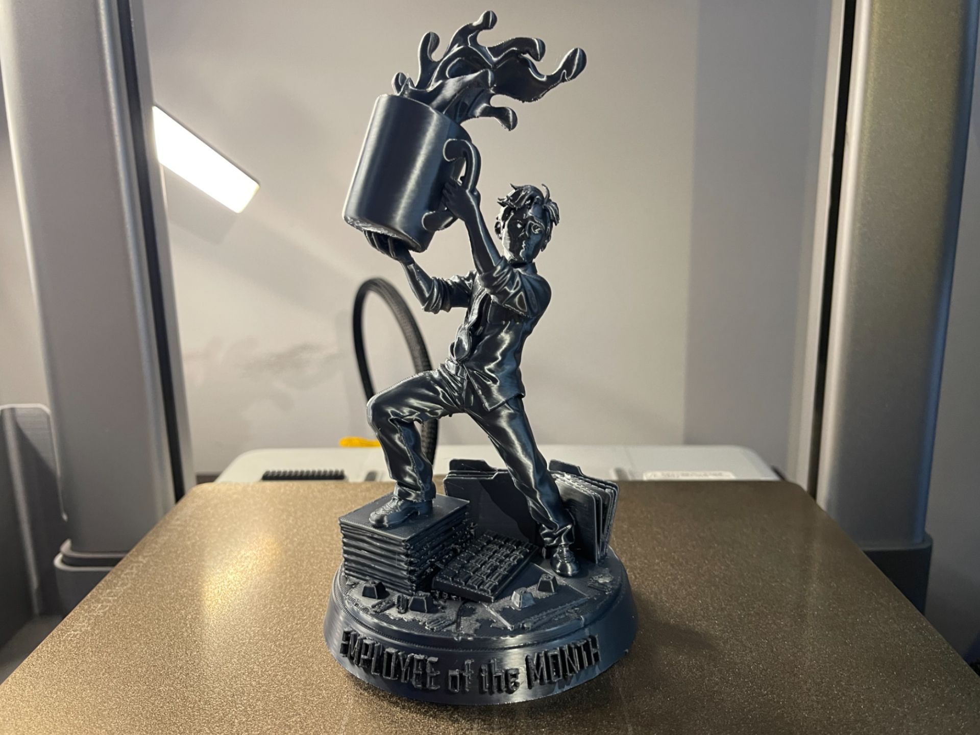 Rig-3d Een metalen, 3D-geprinte figuur staat op een sokkel met het opschrift