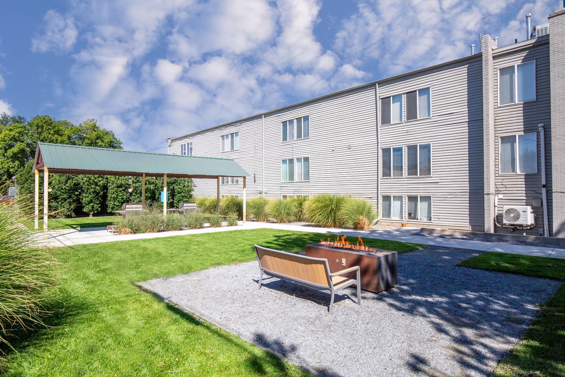 Outdoor seating area with gravel, fire pit, and building.