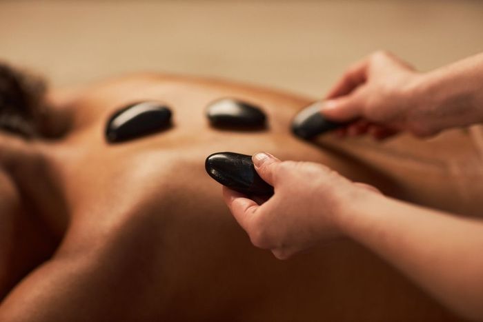 Person on a spa having a hot stone massage.