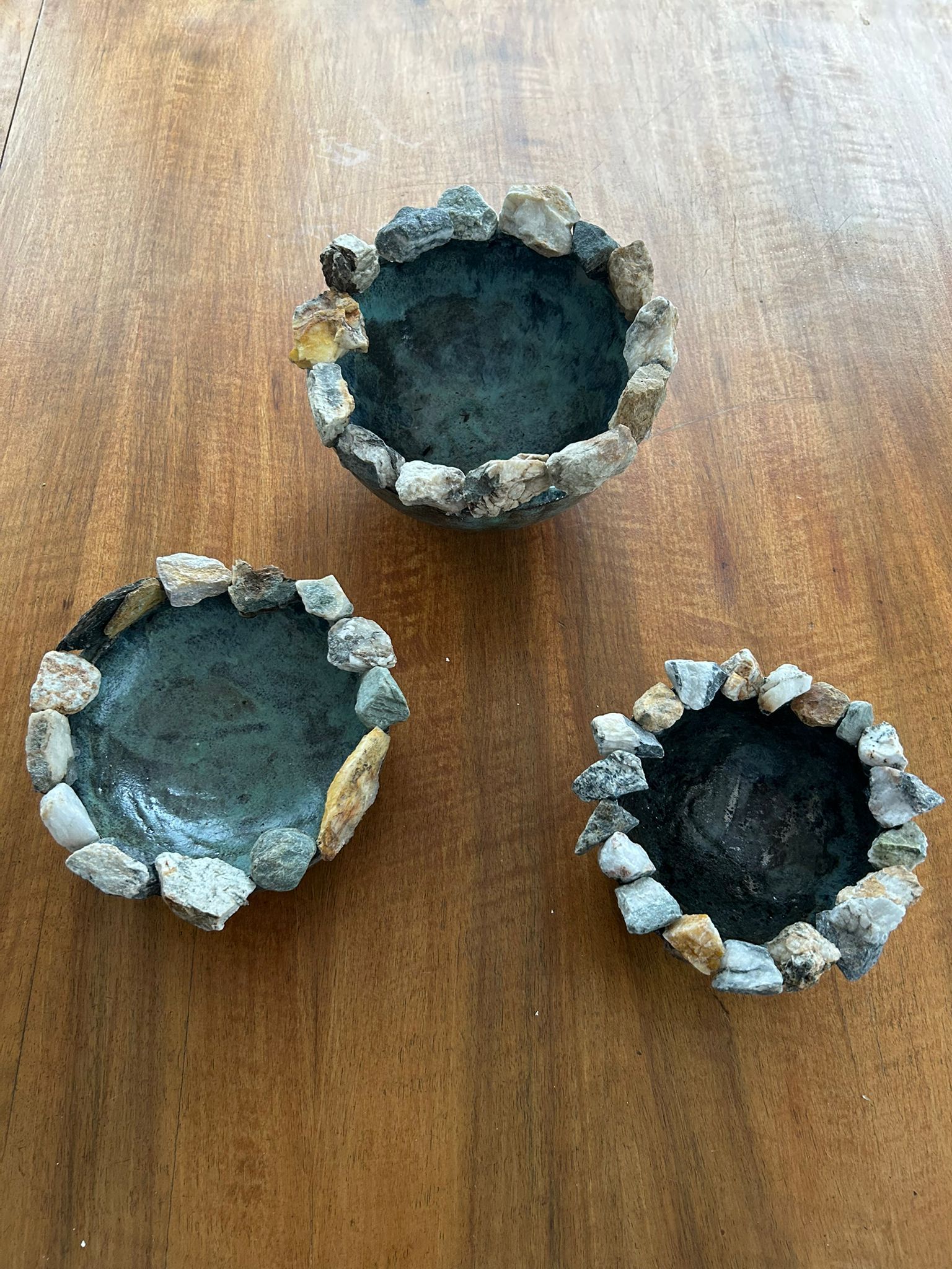 Een tuin met glazen bloemsculpturen en speelse versieringen. Groen gebladerte op de voorgrond, bomen en een zandpad op de achtergrond.